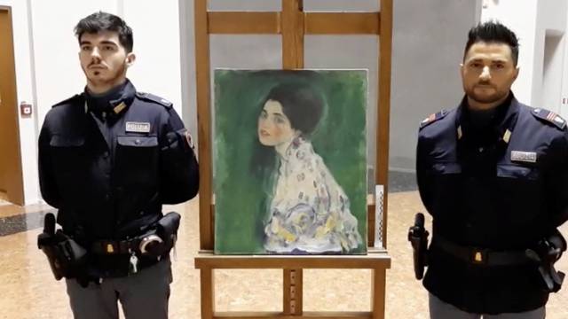 Italian police stand next to what they say is a masterpiece by Austrian artist Gustav Klimt that was stolen in 1997 and was found hidden in an outside wall of an Italian gallery, in Piazcenza