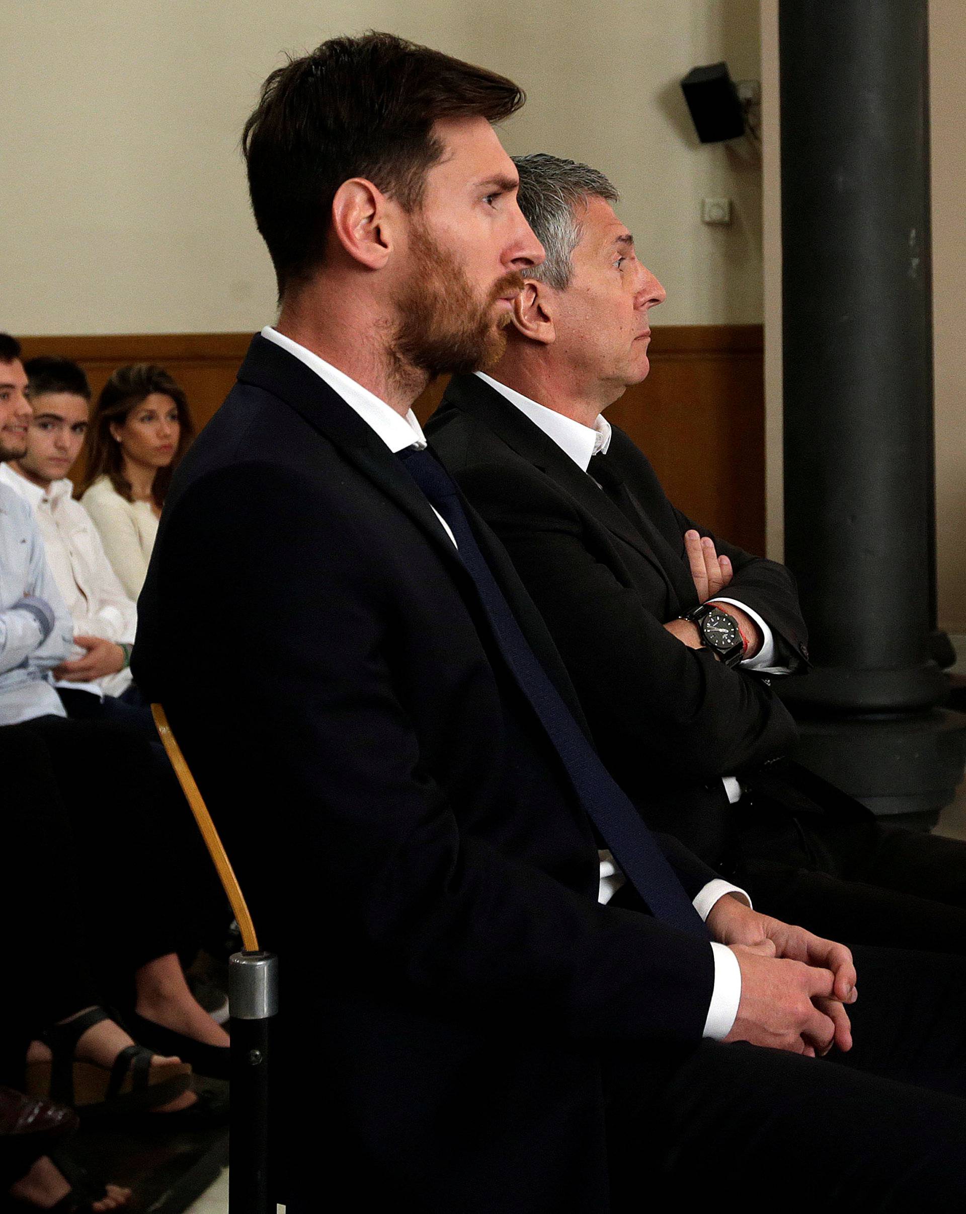 Barcelona's Argentine soccer player Lionel Messi sits in court with his father Jorge Horacio Messi during their  trial for tax fraud in Barcelona