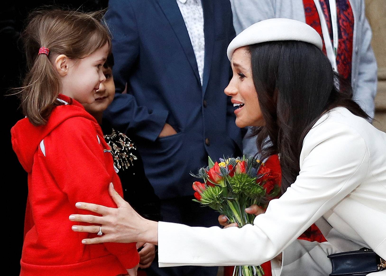 Britain's Prince Harry's fiancee Meghan Markle receives a bouquet of flowers after attending the Commonwealth Service at Westminster Abbey in London