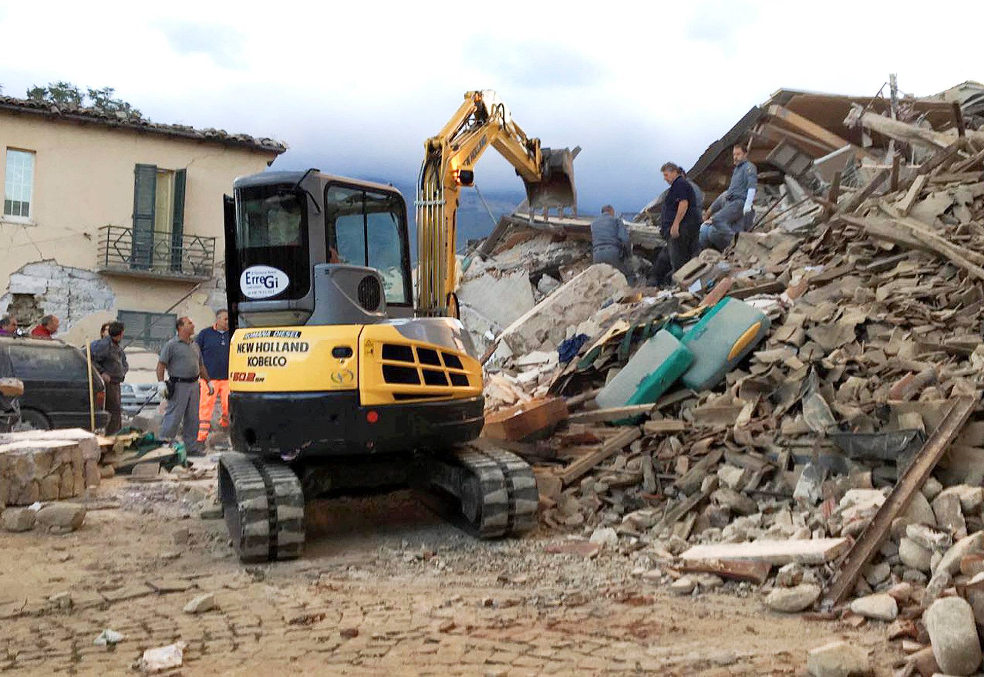 Rescuers work at a collapsed house following a quake in Amatrice