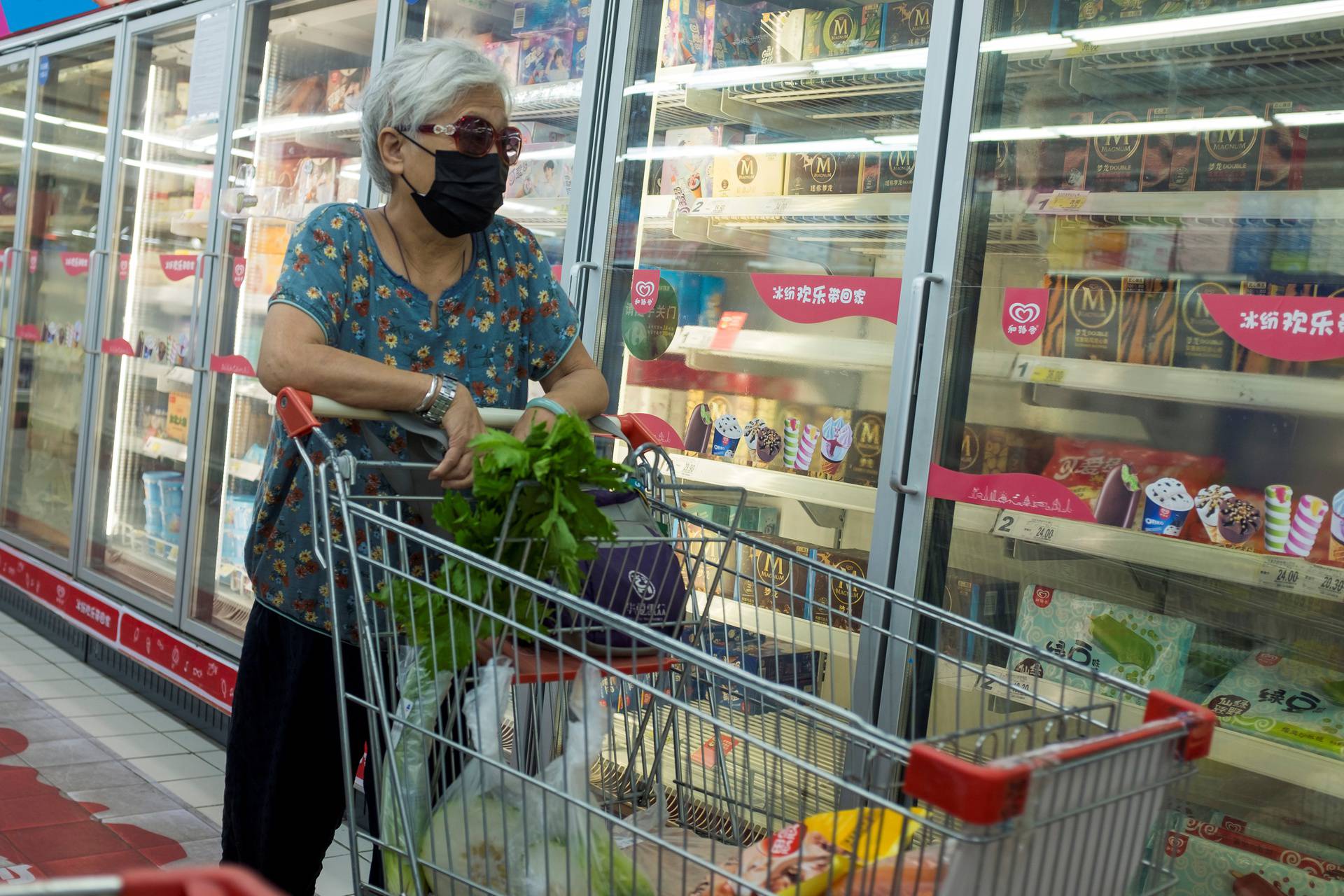 FILE PHOTO: A woman looks at frozen food products in a supermarket in Beijing