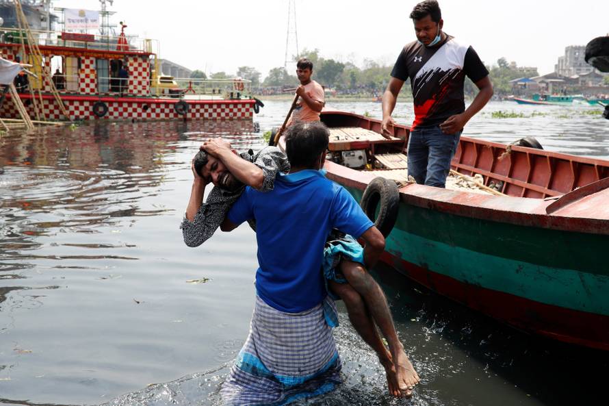 Relatives mourn after several people died due to the collision and sinking of a ferry at the Shitalakhsyaa River in Narayanganj