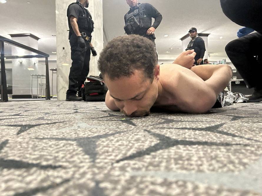 Law enforcement personnel detain Cole Tomas Allen, a suspect in the shooting incident at the White House Correspondents' Association dinner, in Washington