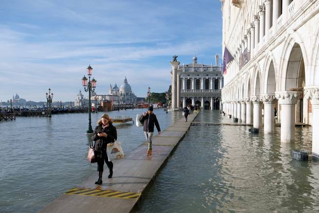 People walk in the flooded St. Mark