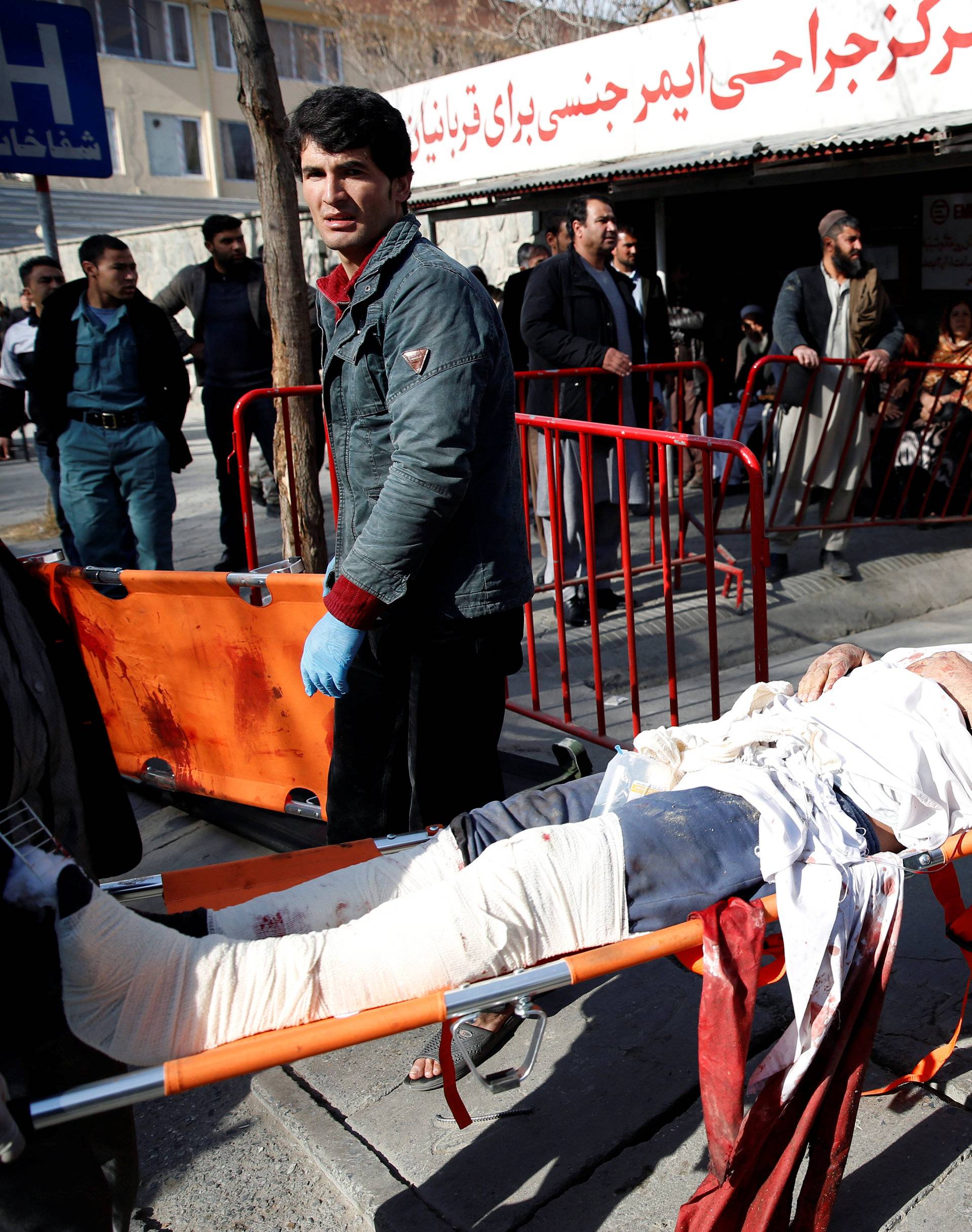 People carry an injured man to a hospital after a blast in Kabul