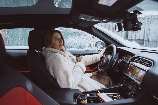 Attractive woman driver nsitting behind the steering wheel in her car