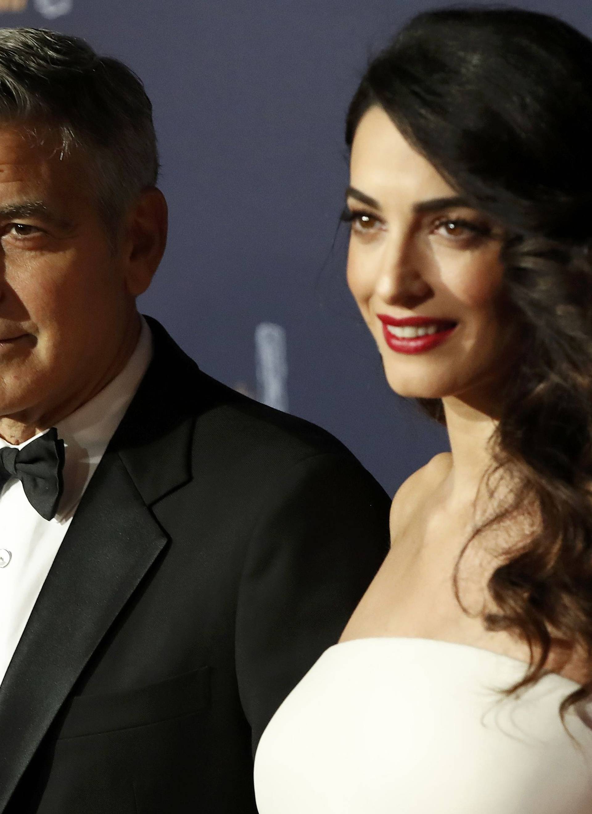 Actor George Clooney and his wife Amal pose as they arrive at the 42nd Cesar Awards ceremony in Paris