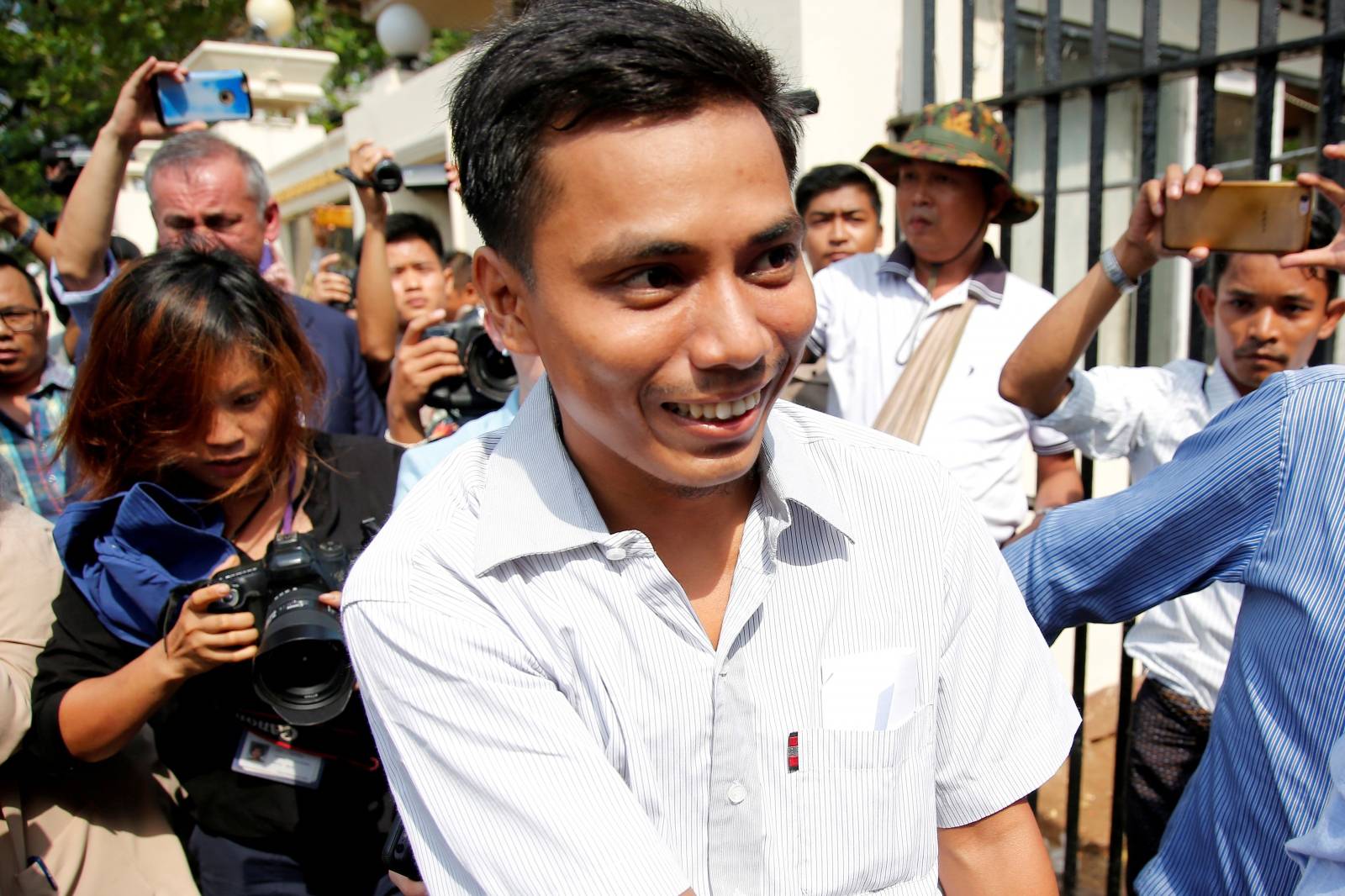 Reuters reporter Kyaw Soe Oo reacts as he walks free outside Insein prison after receiving a presidential pardon in Yangon