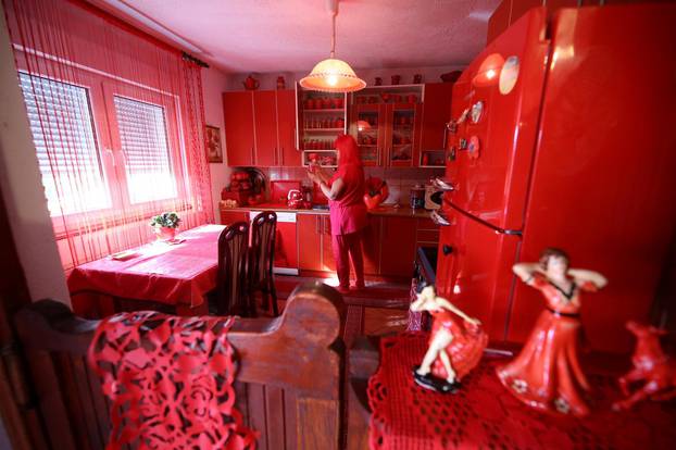 Zorica Rebernik, obsessed with the red color, stands in the kitchen inside her house in the village of Breze near Tuzla