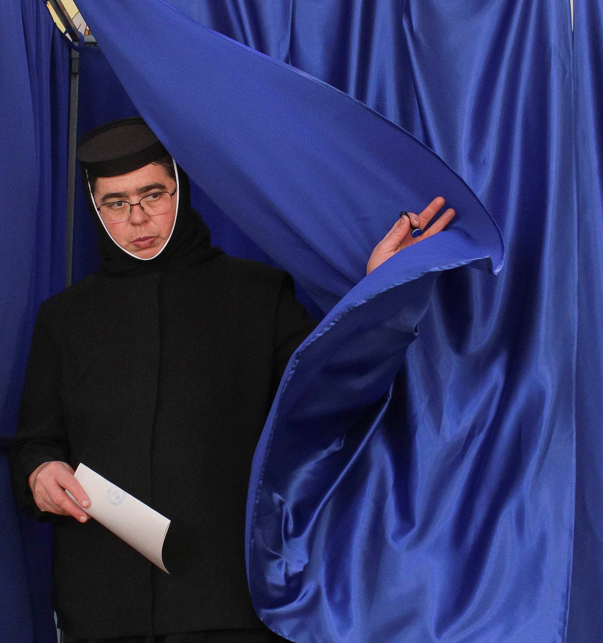 A nun exits a voting booth in Ciorogarla