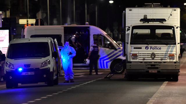 Policemen stand on the scene after Belgian soldiers shot a man who attacked them with a knife, in Brussels