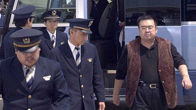 A man believed to be North Korean heir-apparent Kim Jong Nam is escorted by police as he boards a plane upon his deportation from Japan at Tokyo's Narita international airport in Narita, Japan