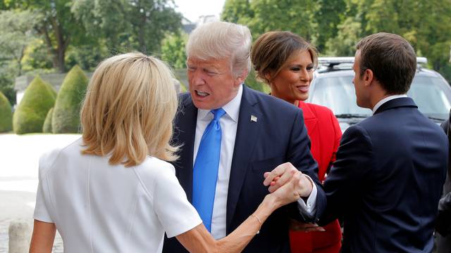 French President Emmanuel Macron greets US First Lady Melania Trump while his wife Brigitte Macron welcomes US President Donald Trump at Les Invalides museum in Paris