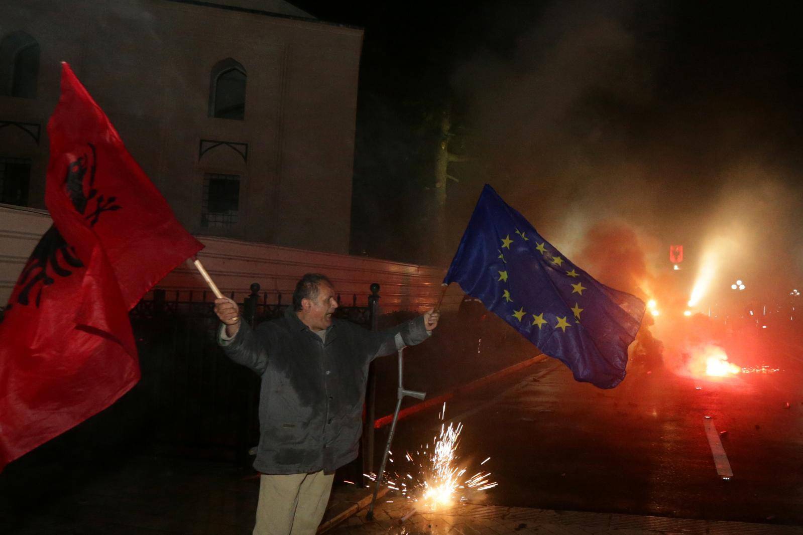 A supporter of the opposition party waves Albanian and European flag during an anti-government protest in front of the Parliament Building in Tirana