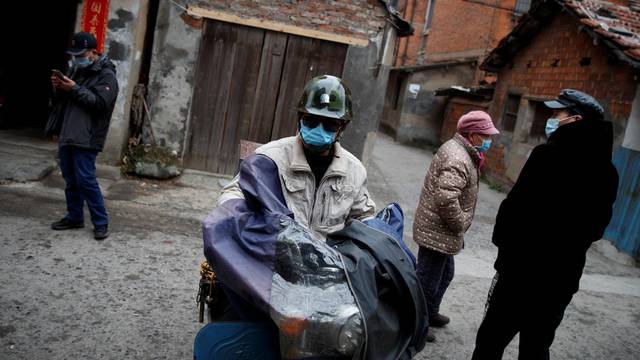 People wear masks in an old neighbourhood in Jiujiang