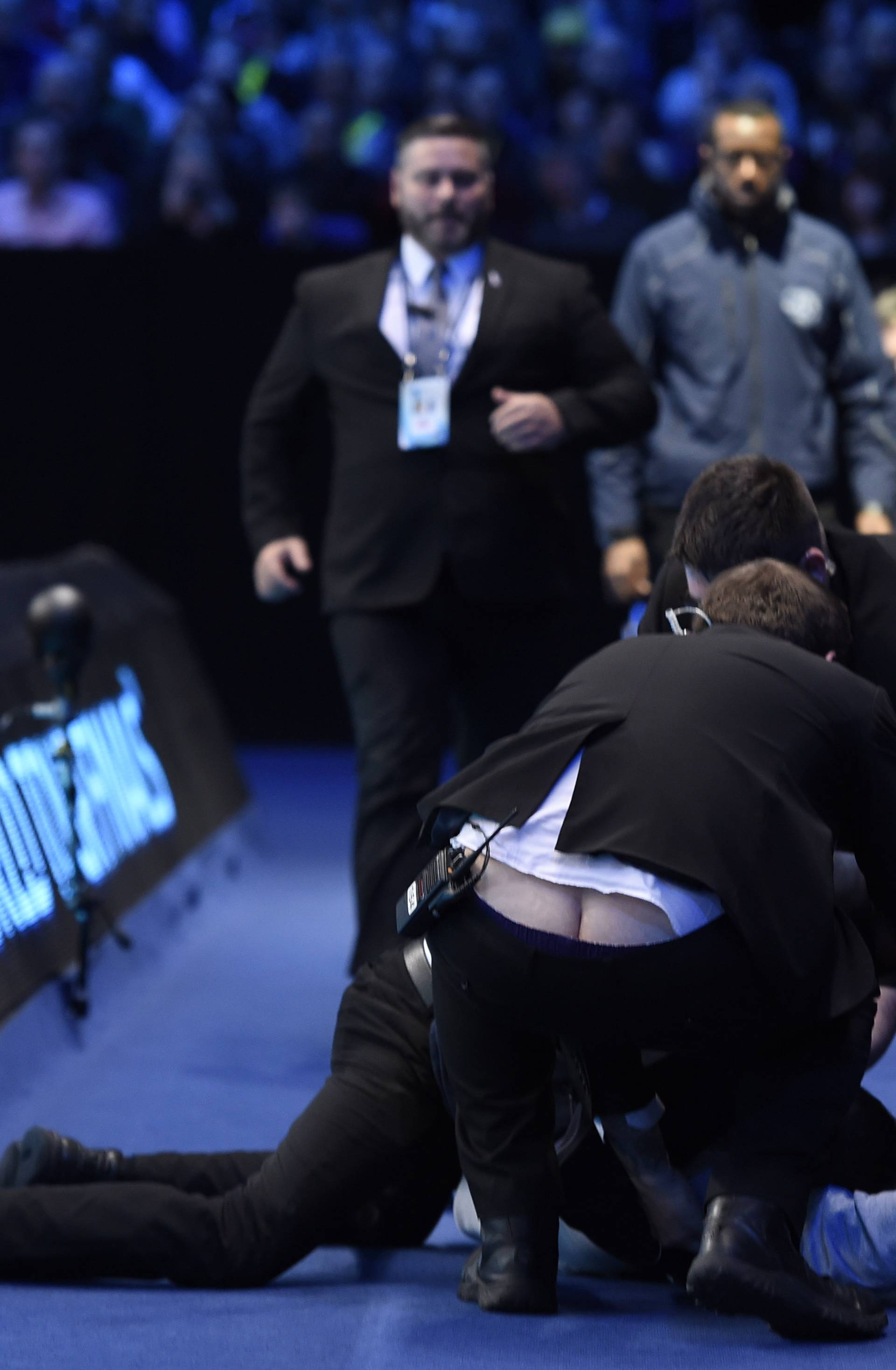 Security apprehend a spectator that attempted to invade the court during the semi final match between Japan's Kei Nishikori and Serbia's Novak Djokovic