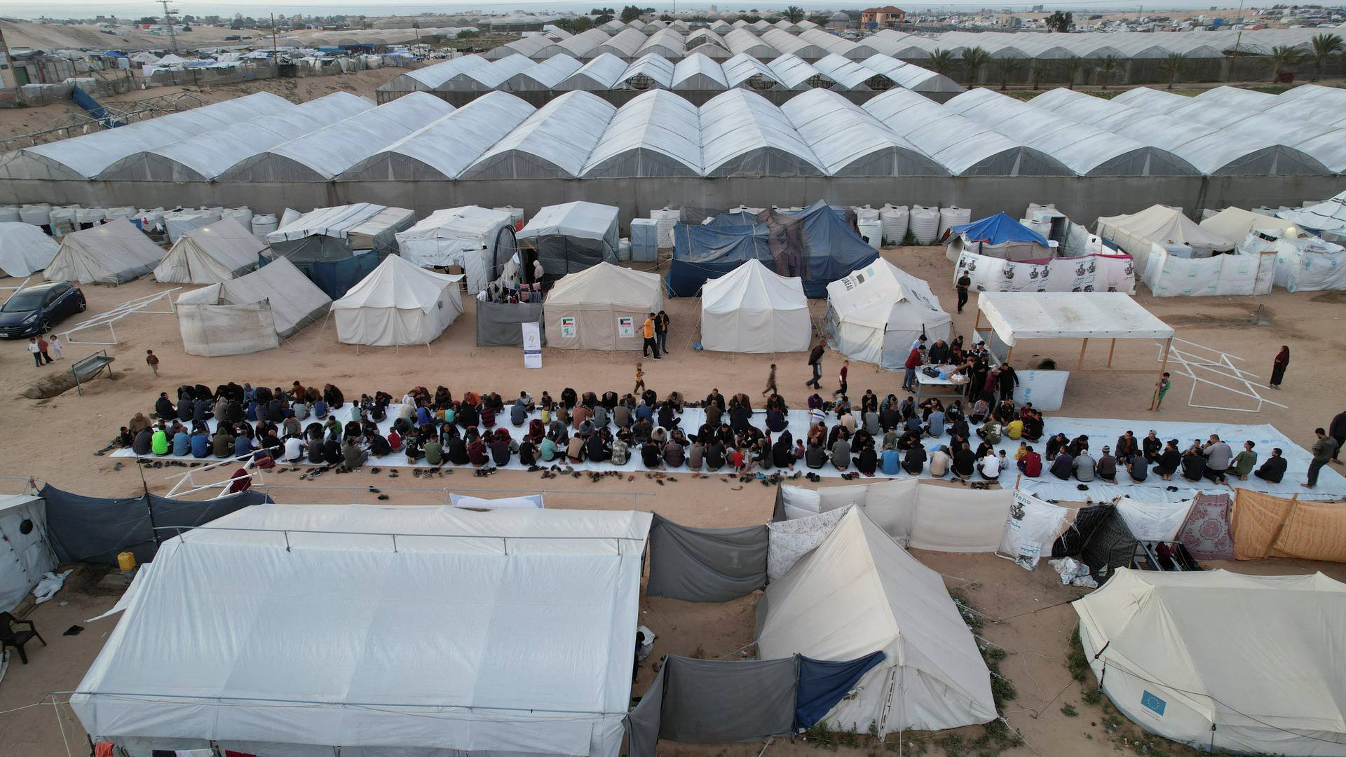 A drone view shows Palestinians, who were displaced by Israel's military offensive, gathering to have their Iftar (breaking of the fast) during the holy month of Ramadan, in Rafah in the southern Gaza Strip