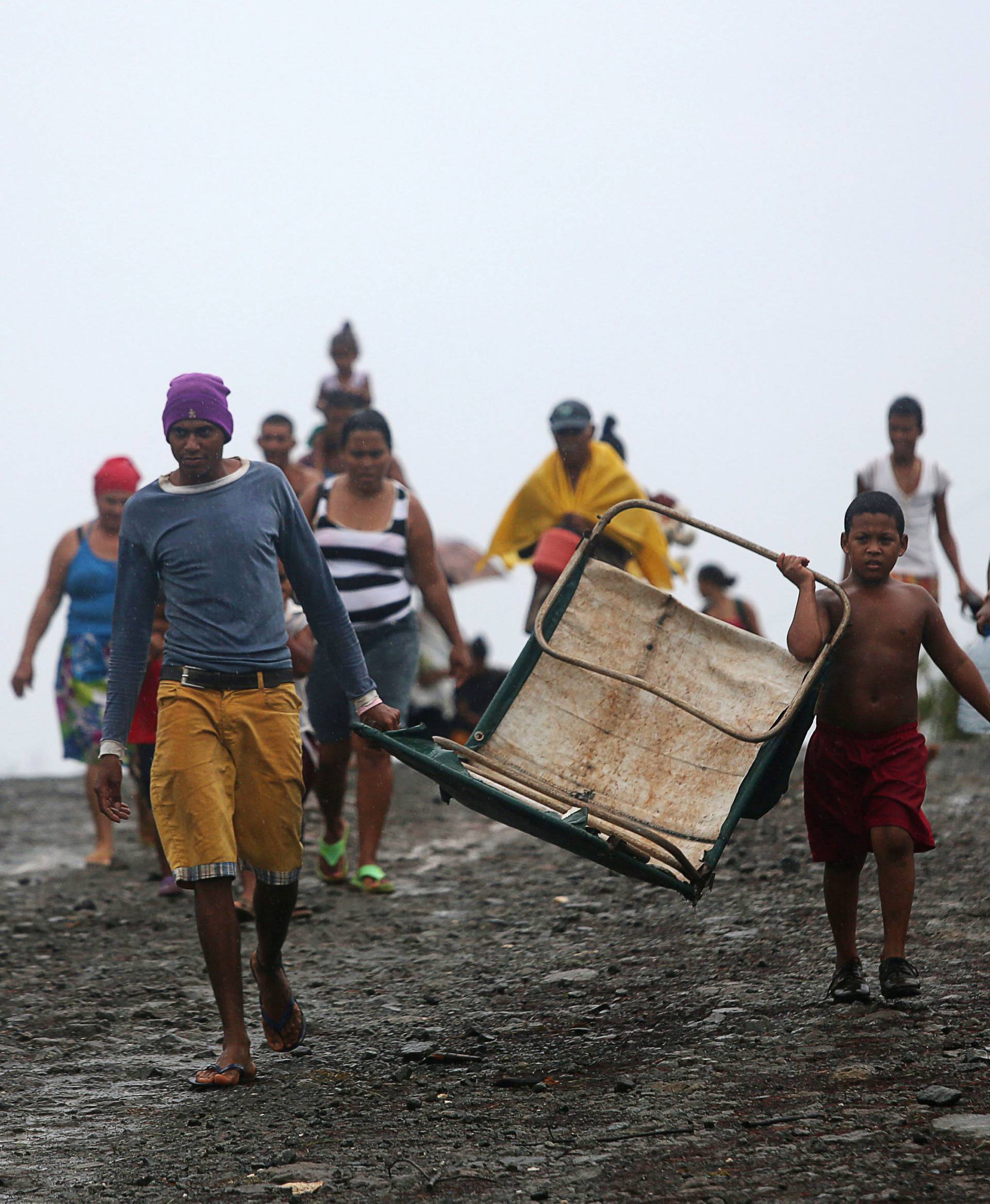 People walk back from shelters to their homes in an ox cart after the passage of Hurricane Matthew in Cayo Grande Yamanigue, Cuba