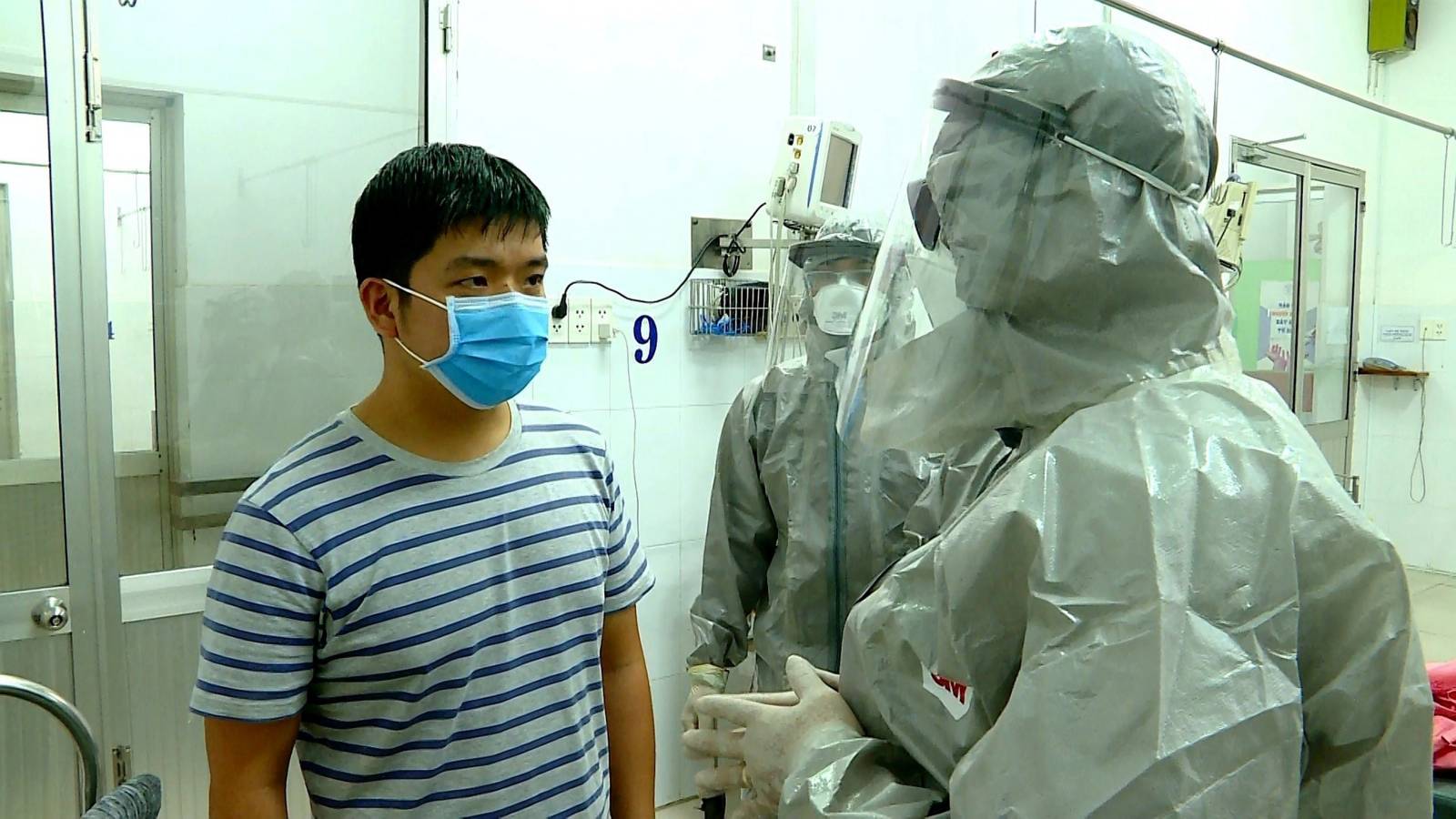 Vietnam's Vice Minister of Health Nguyen Truong Son talks with a man at an isolated section of a hospital where two Chinese citizens had tested positive for coronavirus, in Ho Chi Minh city