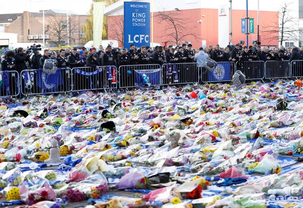 Leicester City players look at tributes left for Leicester City