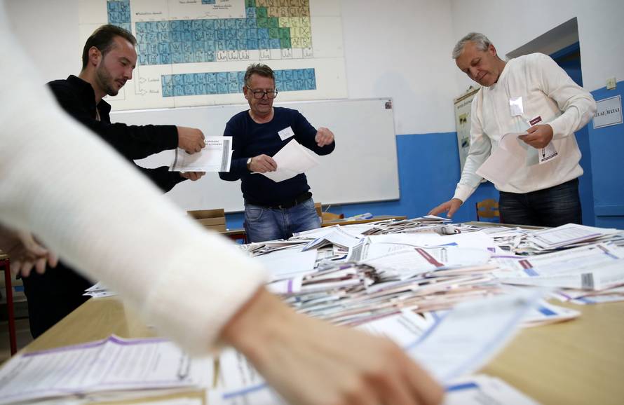 Election Commission officials count votes after presidential and parliamentary elections at a polling station in a school in Zenica