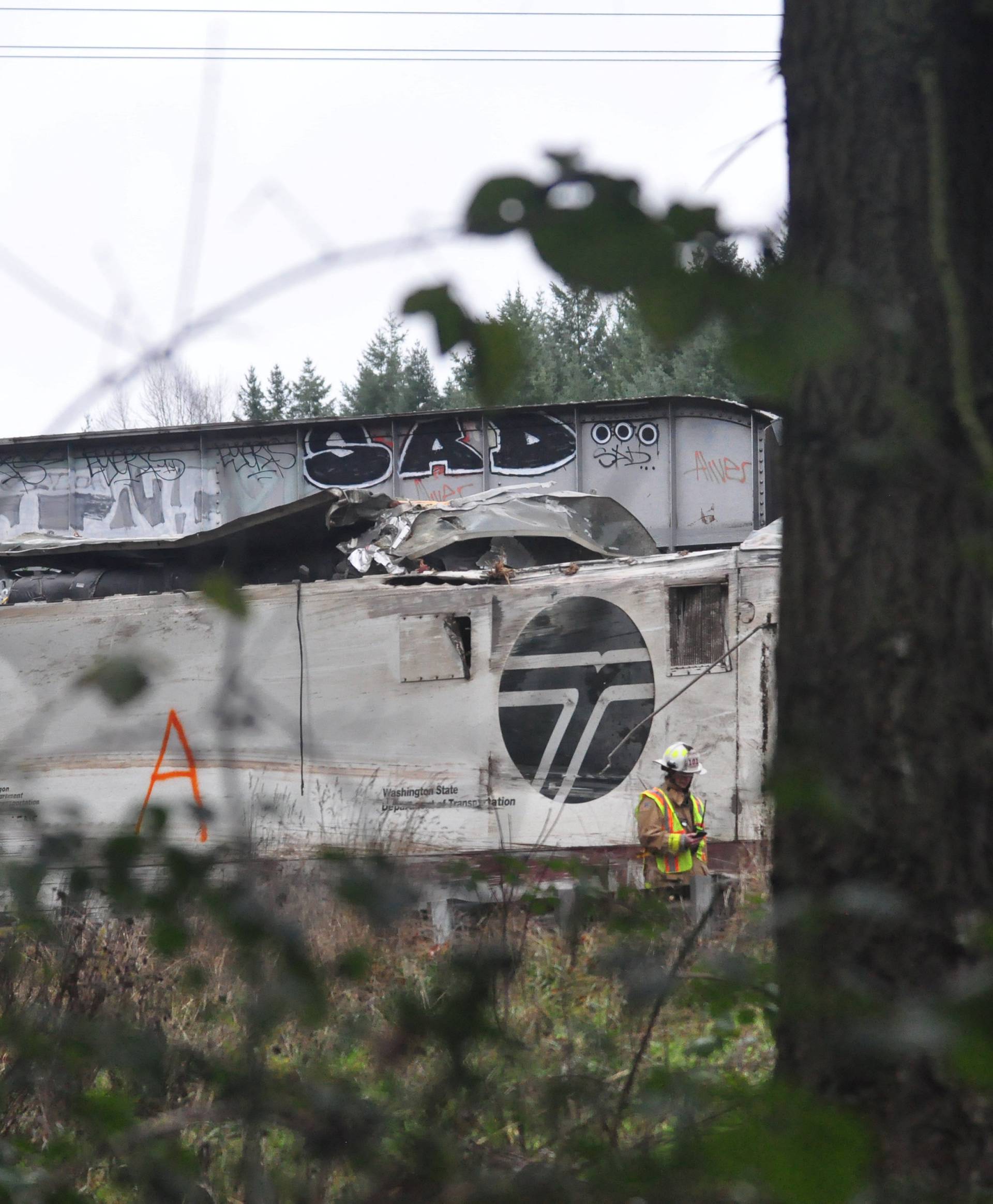 The Amtrak passenger train which derailed is seen hanging from a bridge over the I-5 in DuPont