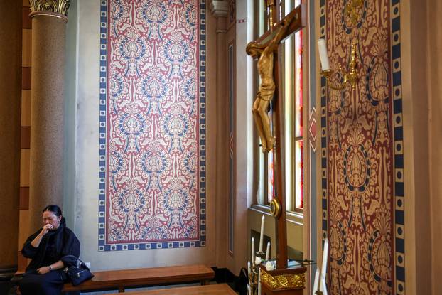 Catholic faithful watch a screen displaying the funeral service of Pope Francis at the Vatican, at the Assumption Cathedral, in Bangkok
