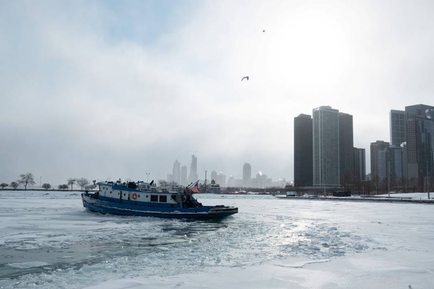 Icebreaker tugboat breaks ice through Lake Michigan in Chicago