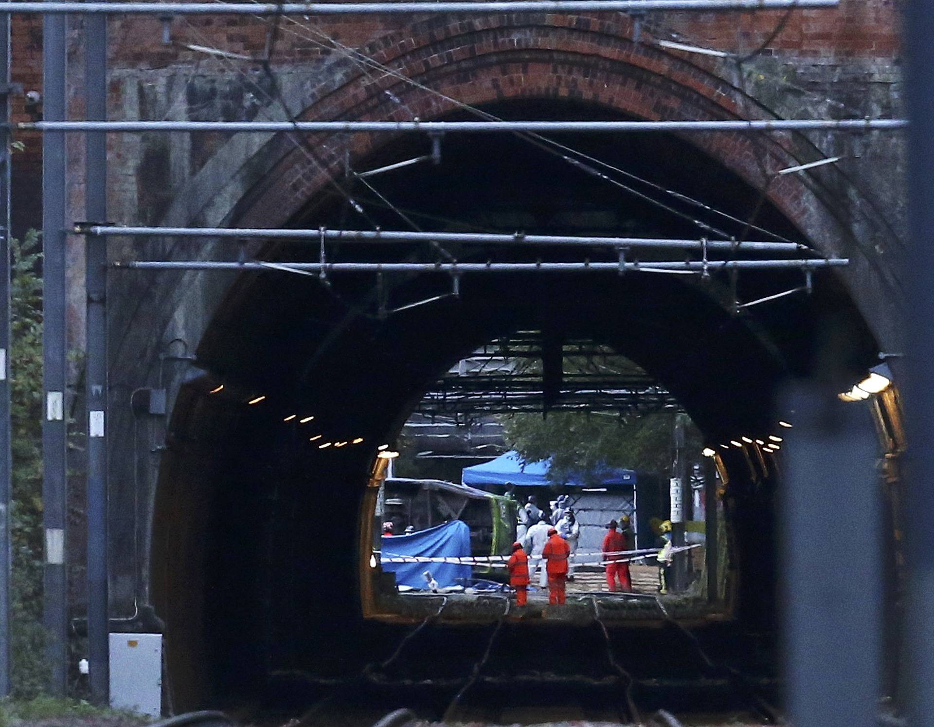 Members of the emergency services work next to a tram after it overturned killing 5 people and injuring 50 passengers in Croydon, south London