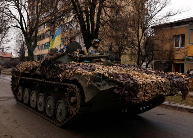 Ukrainian soldiers are pictured on their military vehicle, amid Russia's invasion on Ukraine in Bucha, in Kyiv region