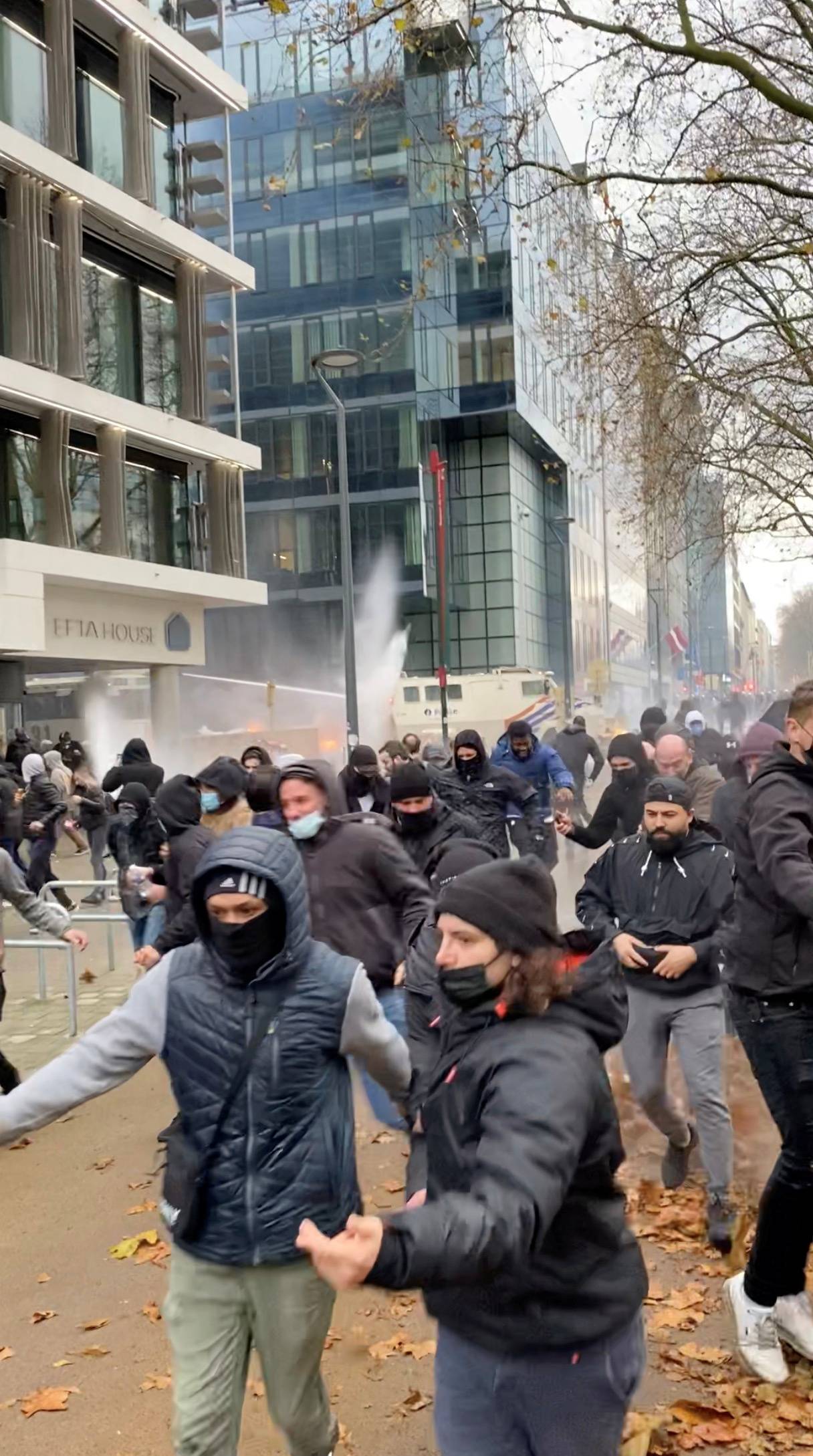 Demonstrators run away from water cannons during a protest, in Brussels