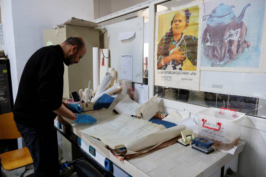 An employee of the Antiquities Inspection Department restores old, neglected maps of the archaeological sites in Benghazi