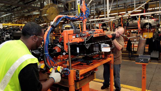 FILE PHOTO: Ford Assembly workers install a battery onto the chassis of a Ford Focus Electric vehicle at the Michigan Assembly Plant in Wayne, Michigan