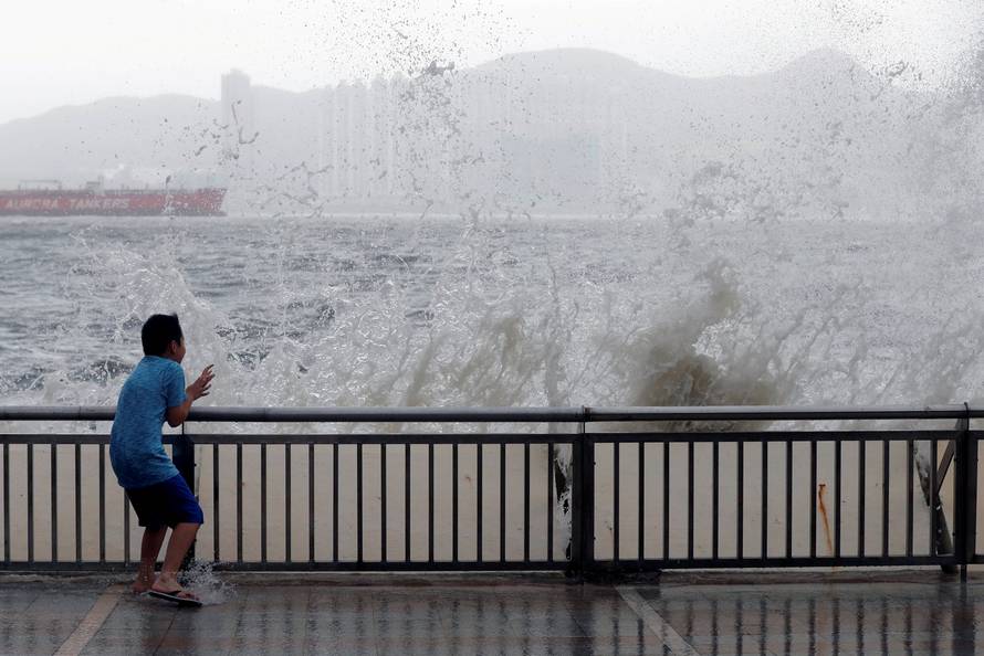 A child reacts after a big wave on a waterfront as Typhoon Hato hits Hong Kong