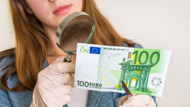 Woman,Viewing,Counterfeit,Euro,Banknote,With,Magnifying,Glass