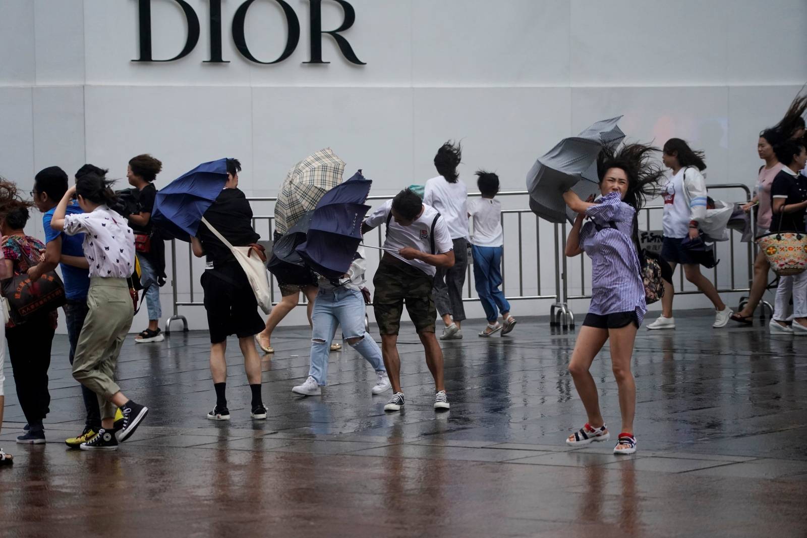 People walk in the rainstorm as typhoon Lekima approaches in Shanghai