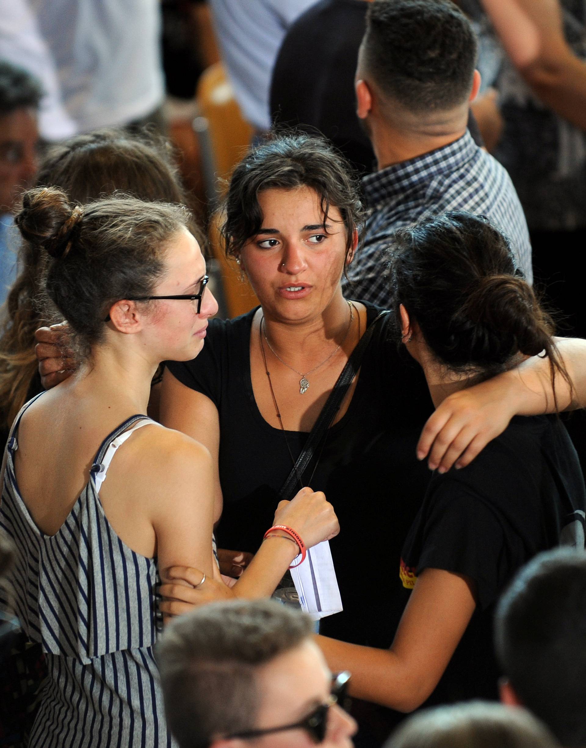 Mourners gather after a funeral service for victims of the earthquake inside a gym in Ascoli Piceno, Italy