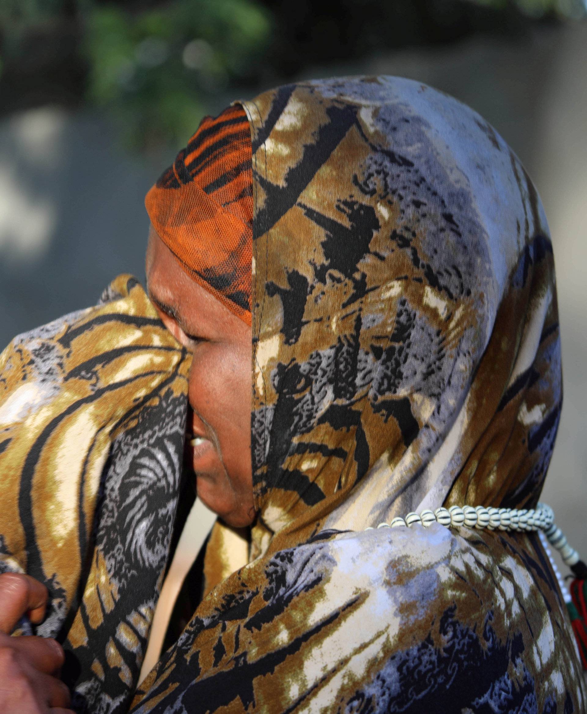 A Somali woman mourns at the scene of a suicide car bomb explosion, at the gate of Naso Hablod Two Hotel in Hamarweyne district of Mogadishu