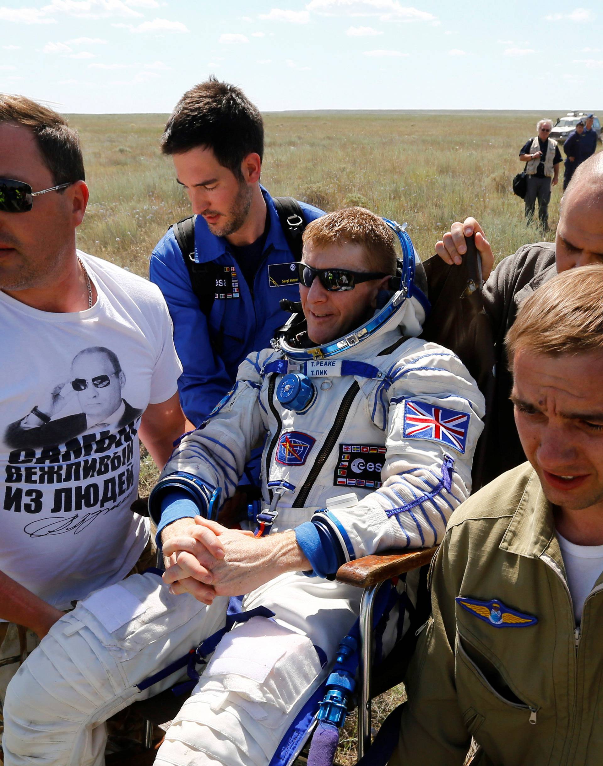 Ground personnel carry ISS crew member Peake of Britain shortly after landing near Dzhezkazgan