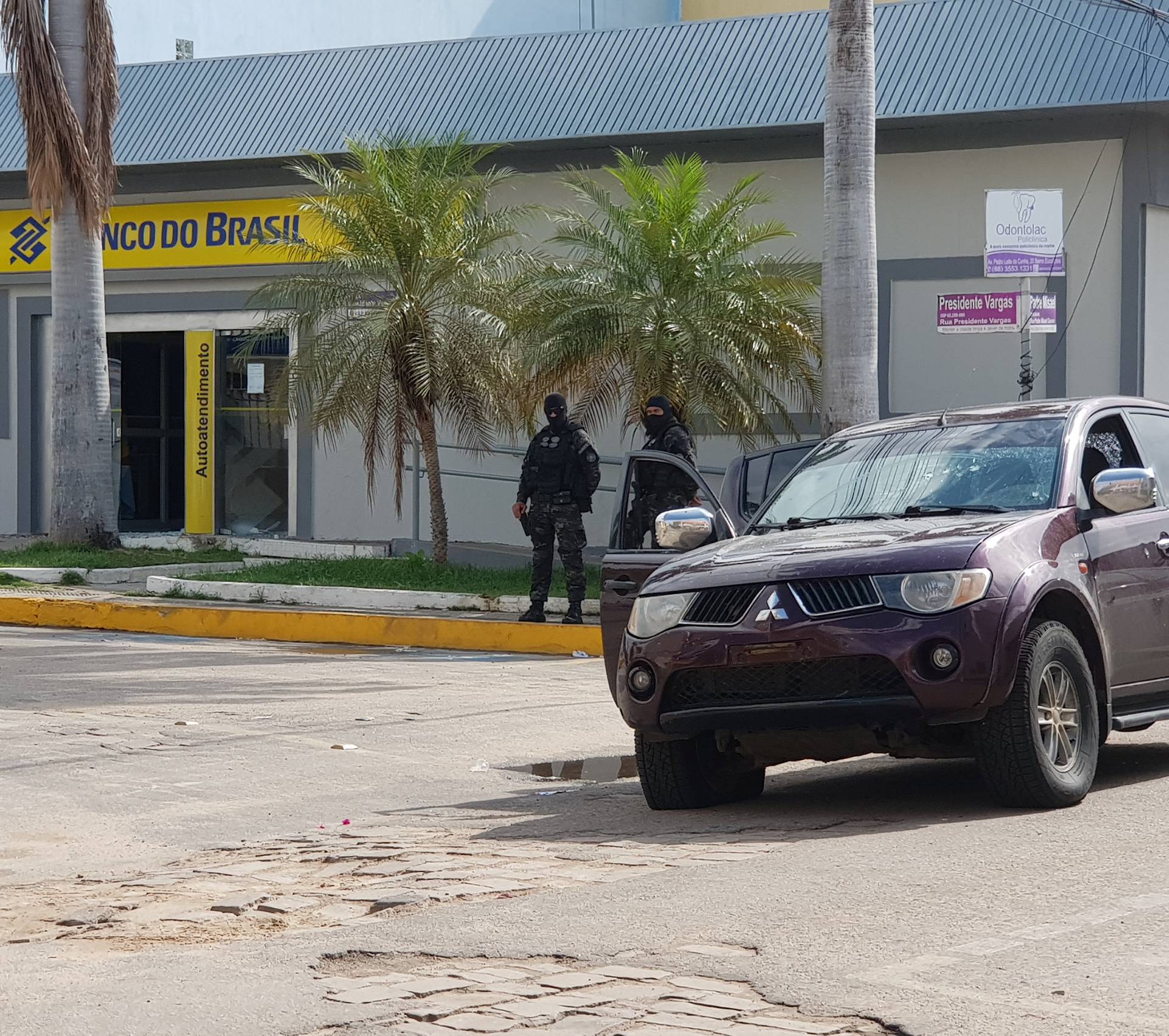 Policemen stand in front of the Banco do Brasil branch after a shootout between police and bank robbers, in Milagres