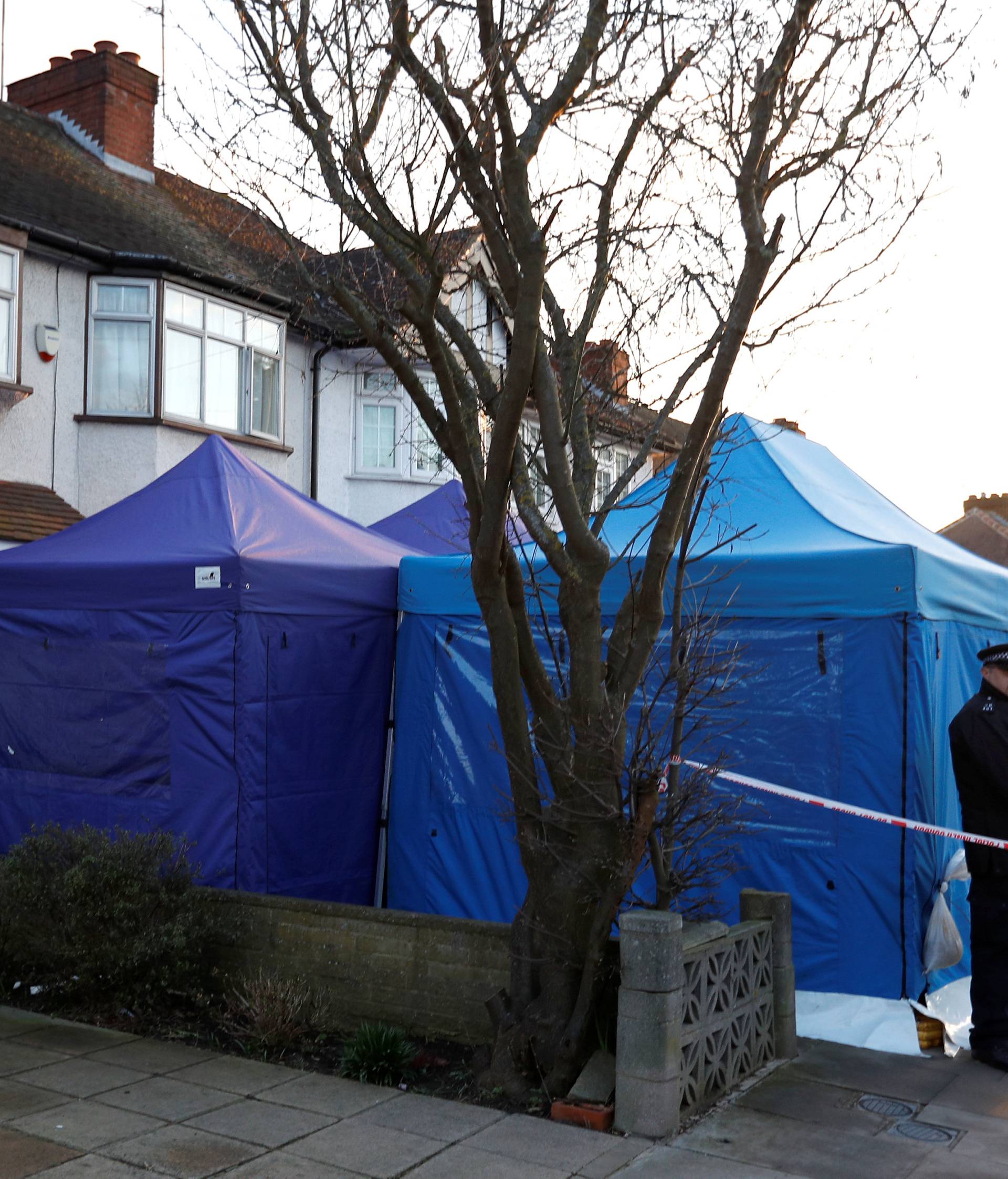 A police officer stands guard outside the home of Nikolai Glushkov in New Malden