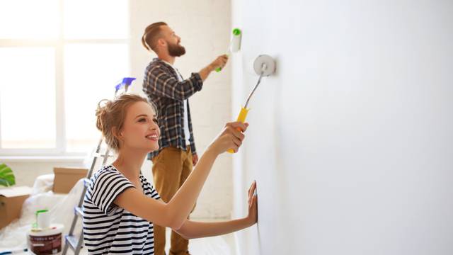 Young,Happy,Couple,Is,Repairing,And,Painting,The,Wall,At
