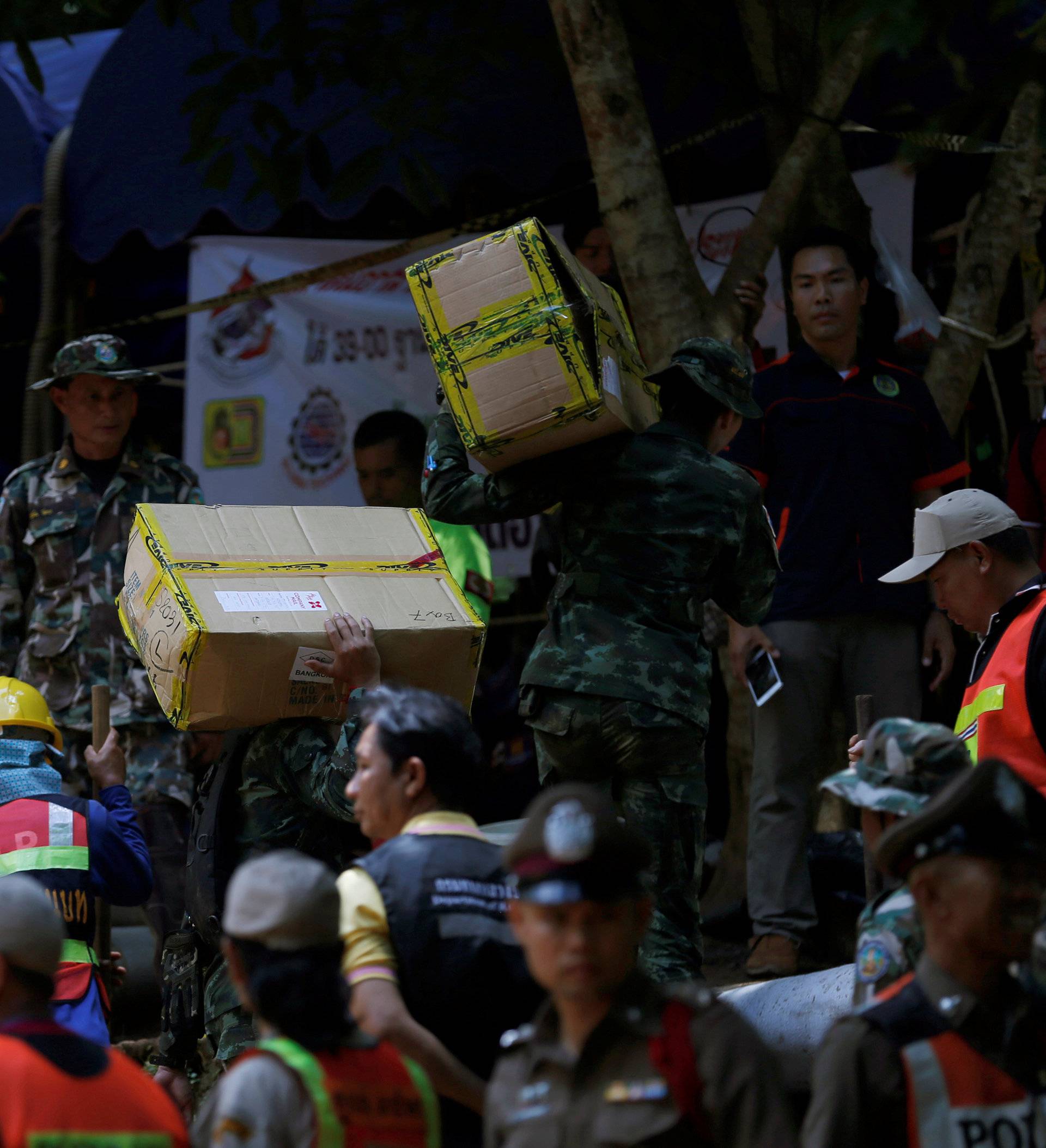 Soldiers and rescue workers carry aid supplies to the Tham Luang cave complex, as members of an under-16 soccer team and their coach have been reported by local media to be found alive, in Chiang Rai