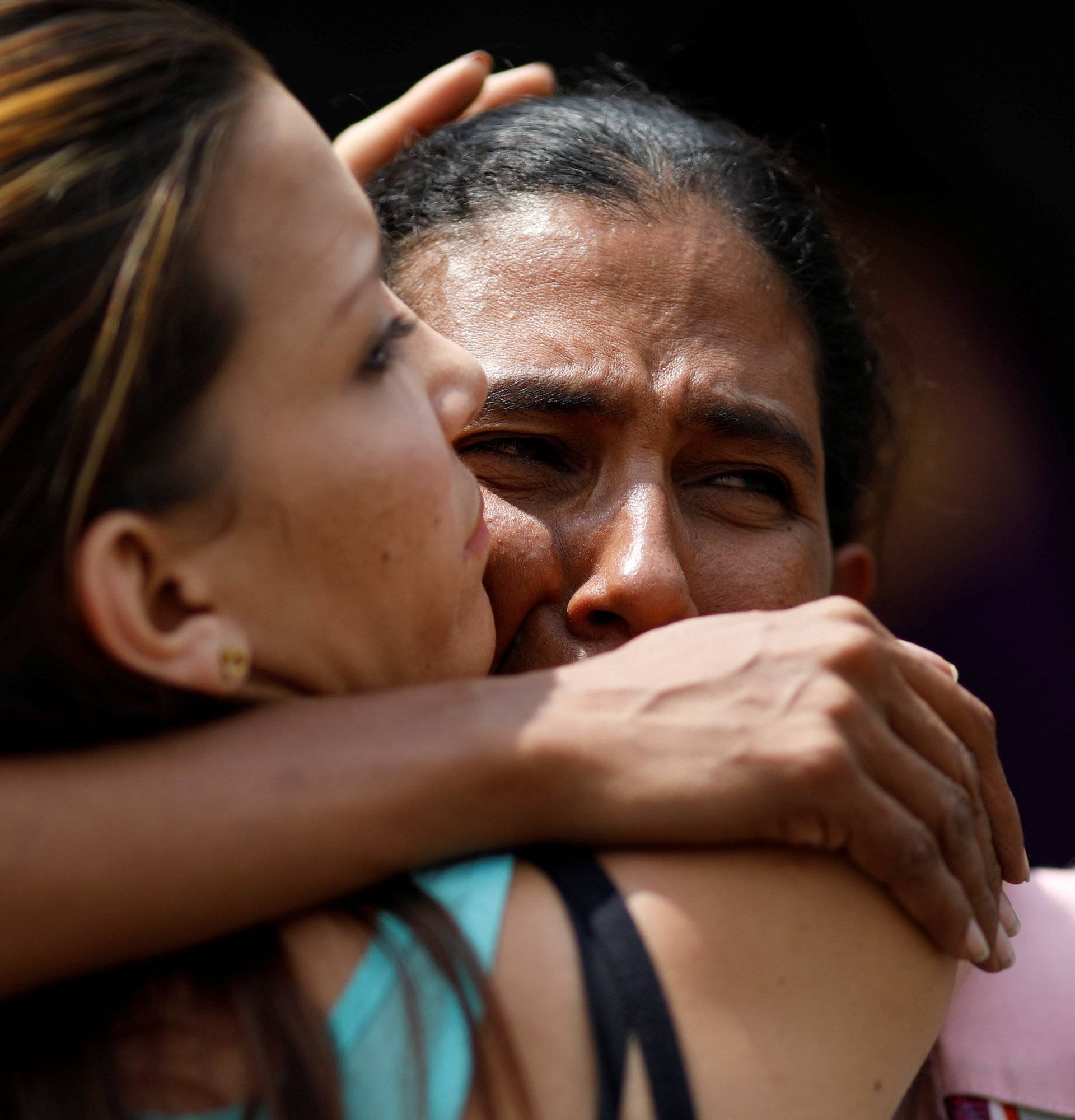 Relatives of the inmates who died during a riot and a fire in the cells of the General Command of the Carabobo Police, react outside a funeral home in Valencia
