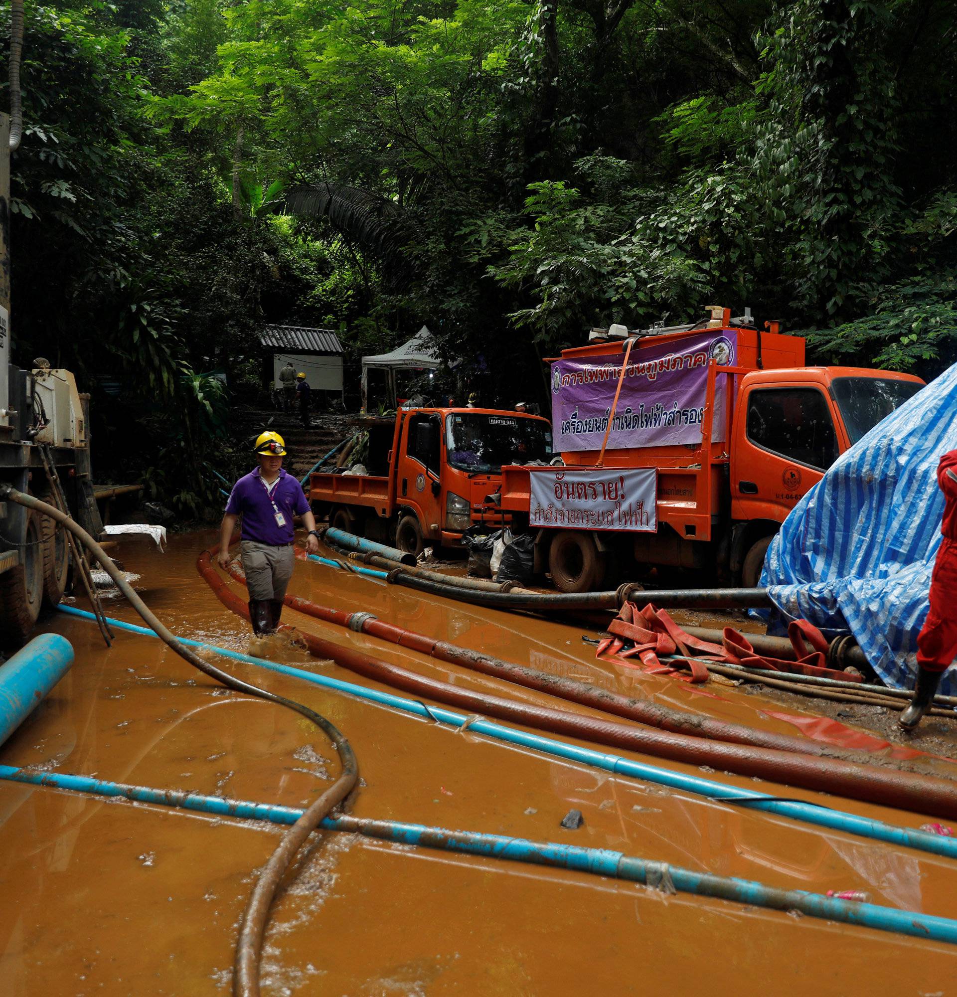 Rescue workers come out from the Tham Luang cave complex, as members of under-16 soccer team and their coach have been found alive according to a local media's report, in the northern province of Chiang Rai