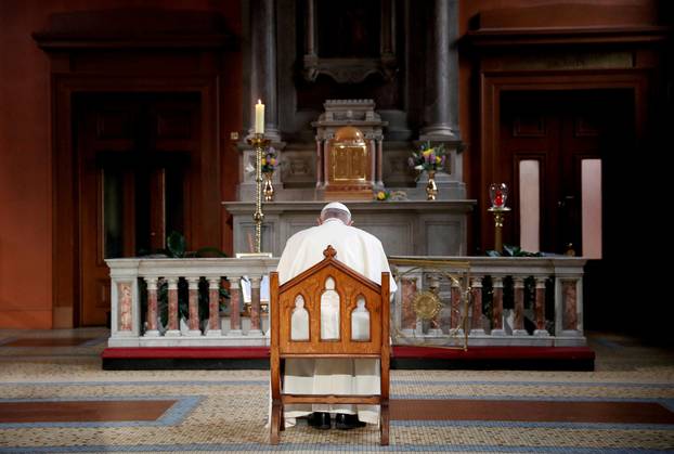 FILE PHOTO: Pope Francis prays in front of a candle lit to remember victims of abuse by the church, inside St Mary's Pro Cathedral during his visit to Dublin