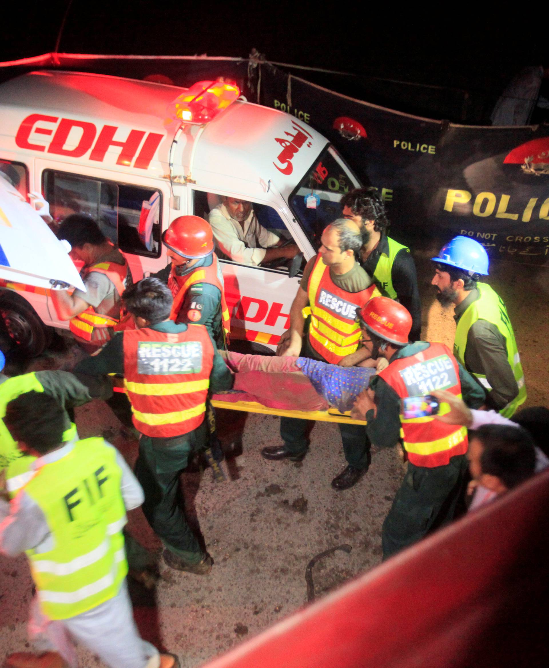 Rescue personnel carry a girl rescued from a collapsed building after a blast in Lahore