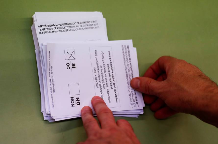 Poll workers count ballots after polls closed at a polling station for the banned independence referendum in Barcelona