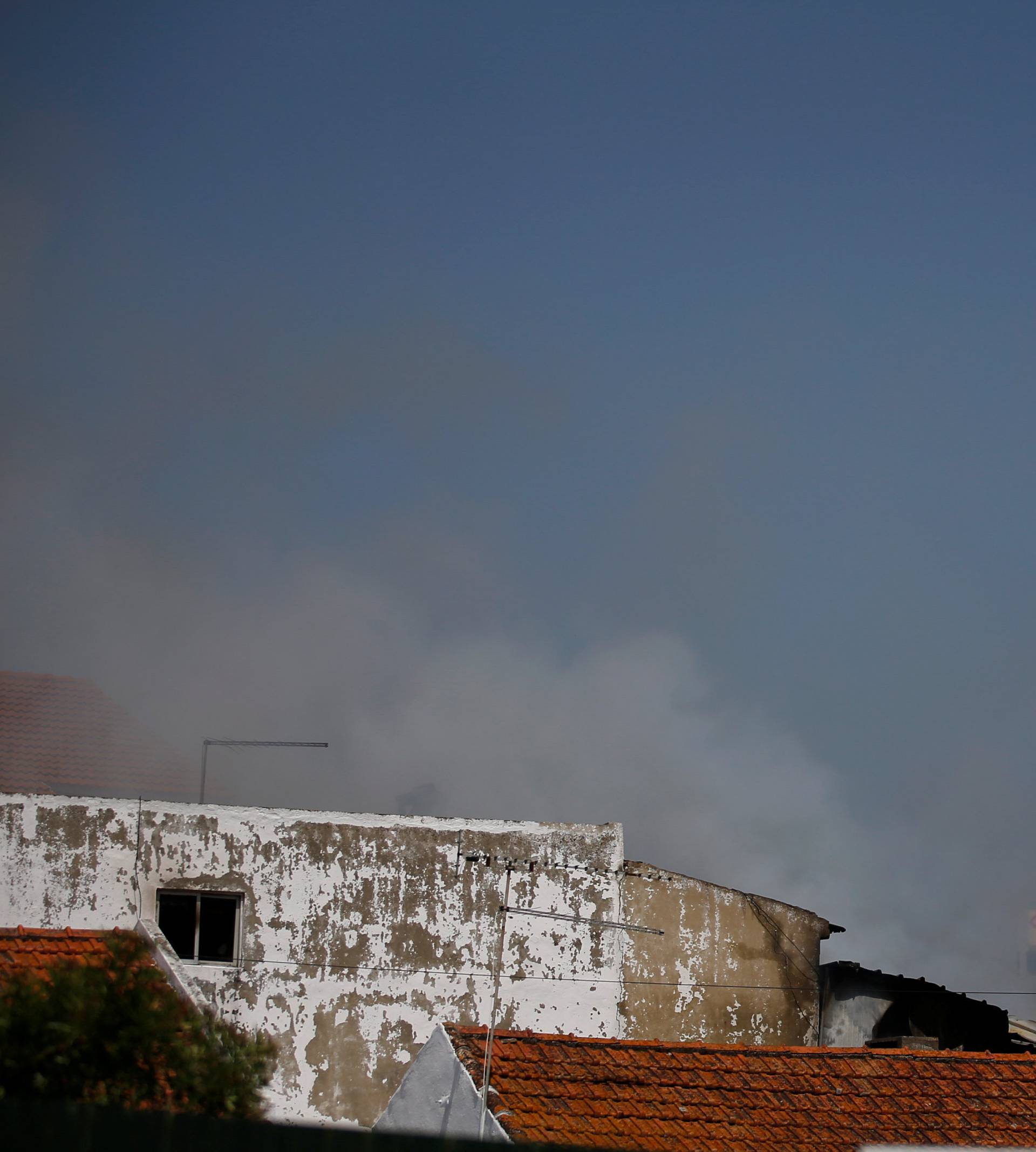 Smoke is seen where a small airplane crashed near a supermarket in a residential area outside Lisbon