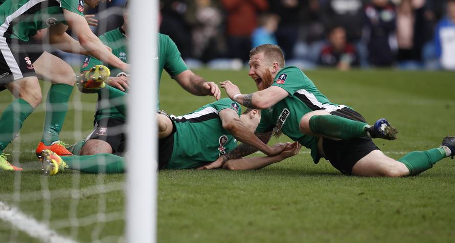 Lincoln's Sean Raggett celebrates scoring their first goal with teammates